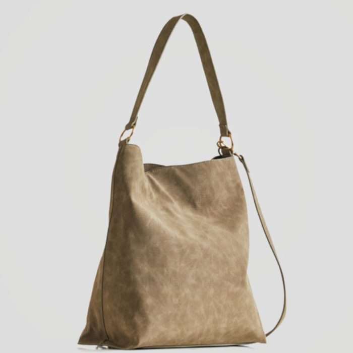 Bolso tipo saco en color verde militar en tejido labrado de imitación piel vuelta. Tiene un mandala grabado en la parte frontal. Es Bag & Play e incorpora un pequeño bolso bandolera en su interior.